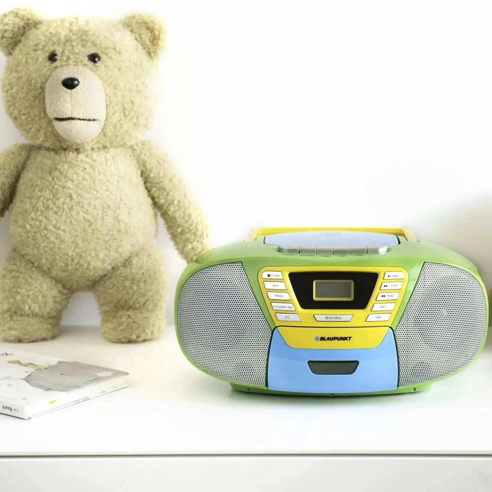 Kinder Boombox mit CD Player in grün, gelb und blau, neben einem Plüschbär auf weißem Hintergrund
