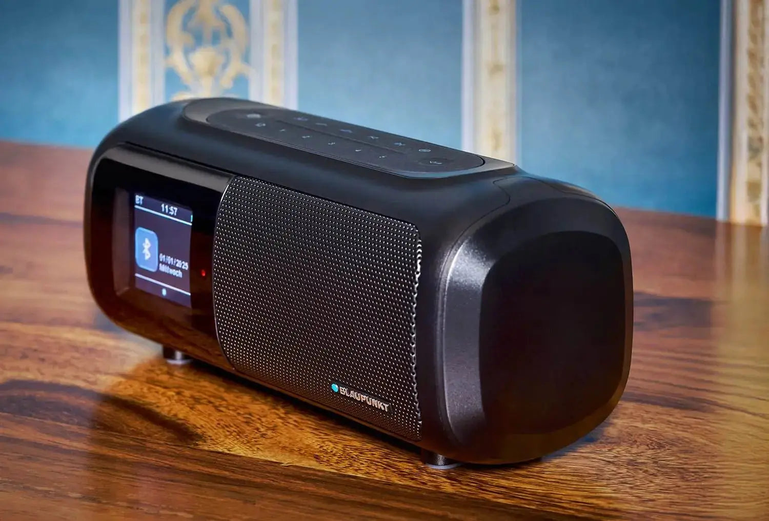Schwarzes DAB Radio mit Bluetooth und farbigem Display auf Holztisch