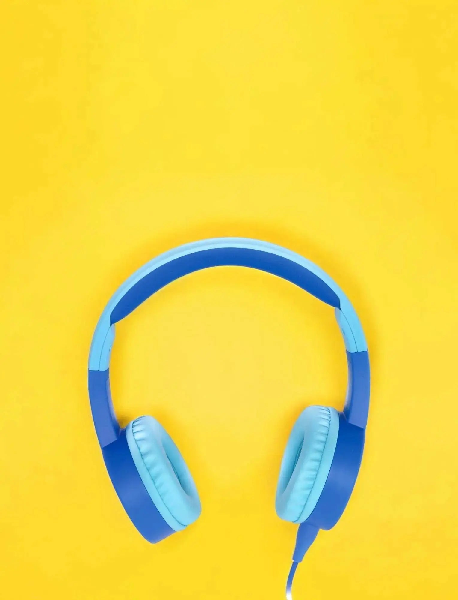 blauer Kinderkopfhörer mit KidsSafe-Technologie und Lautstärkebegrenzung auf gelbem Hintergrund